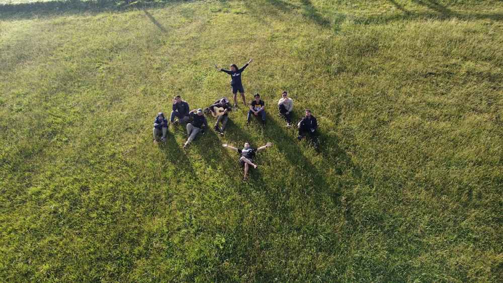 a group of people standing on top of a lush green field