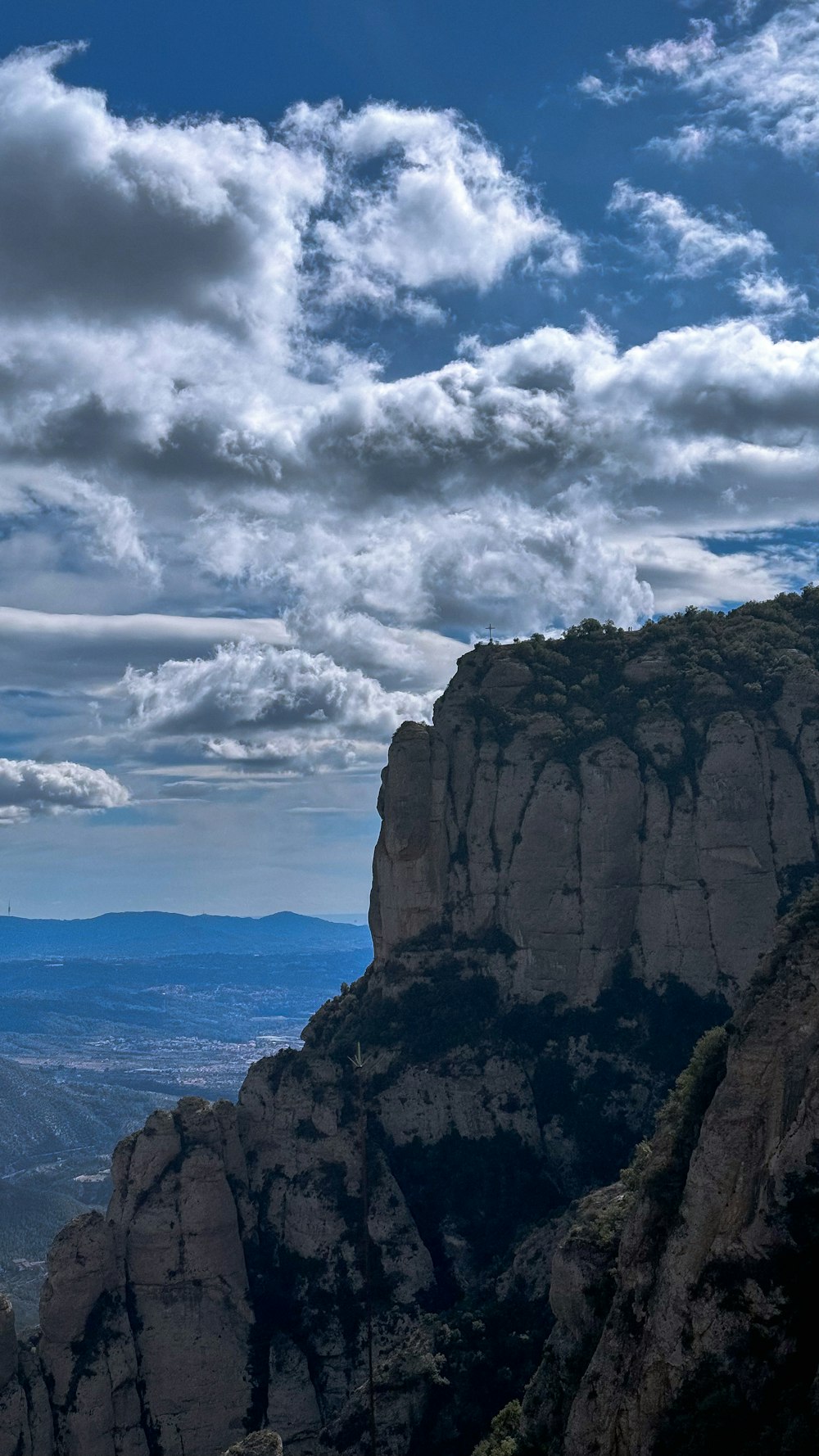 a person standing on top of a mountain with a sky background