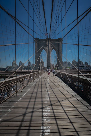 people walking across the brooklyn bridge in new york city