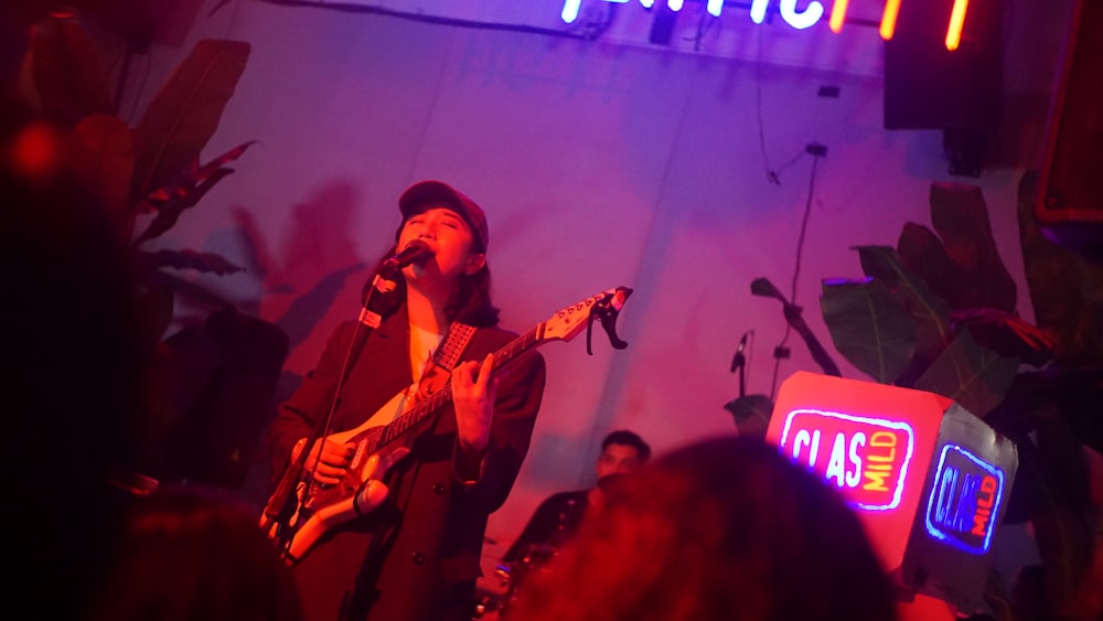 a man playing a guitar in front of a crowd