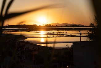 the sun is setting over a body of water