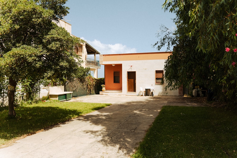 a house with a driveway and trees in front of it