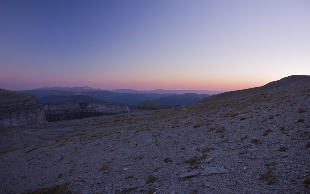 the sun is setting over the mountains in the distance