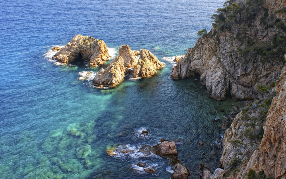 a body of water next to a rocky cliff