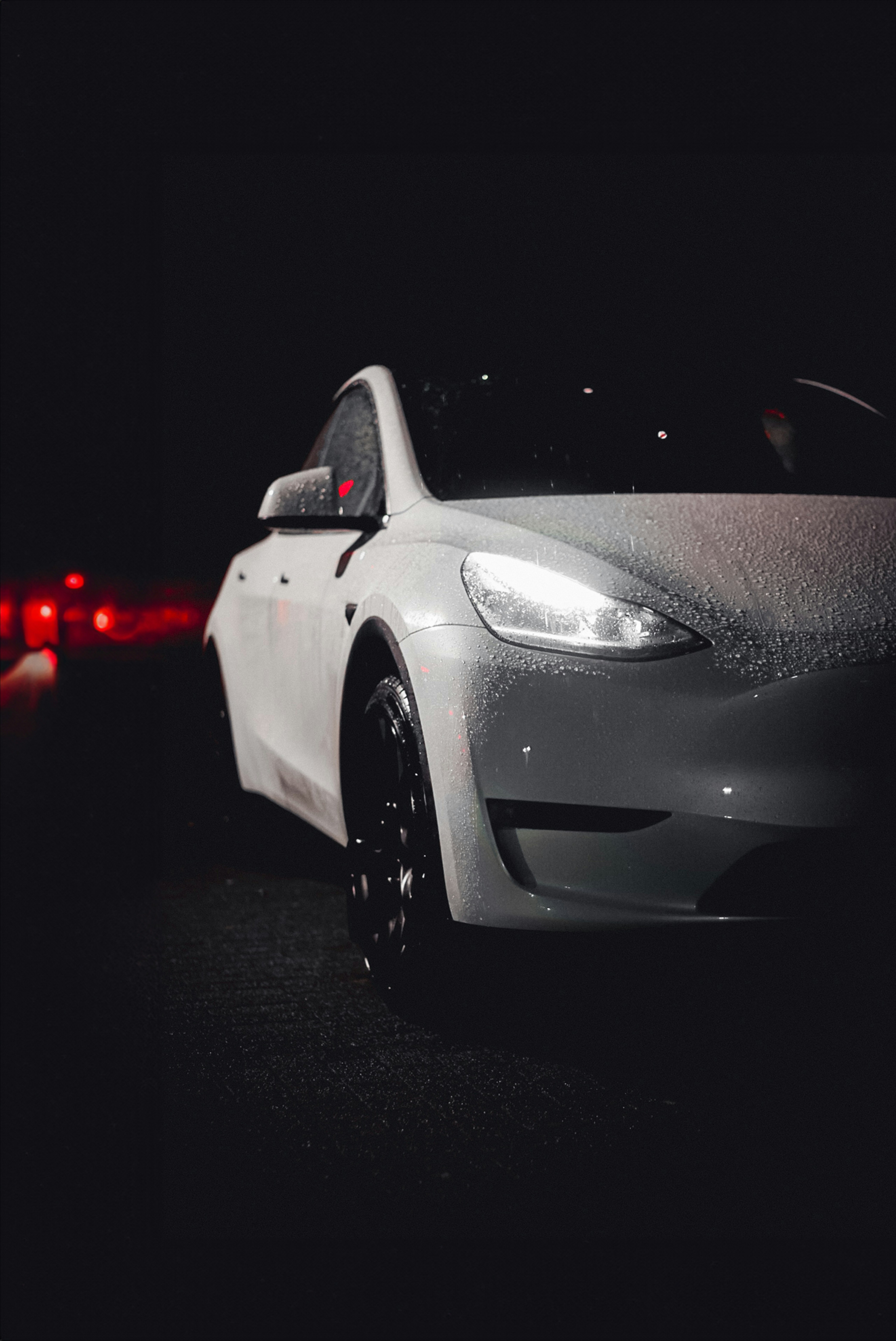 white Tesla with headlights on