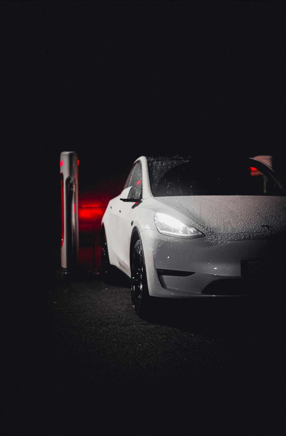 a white car parked next to a red light