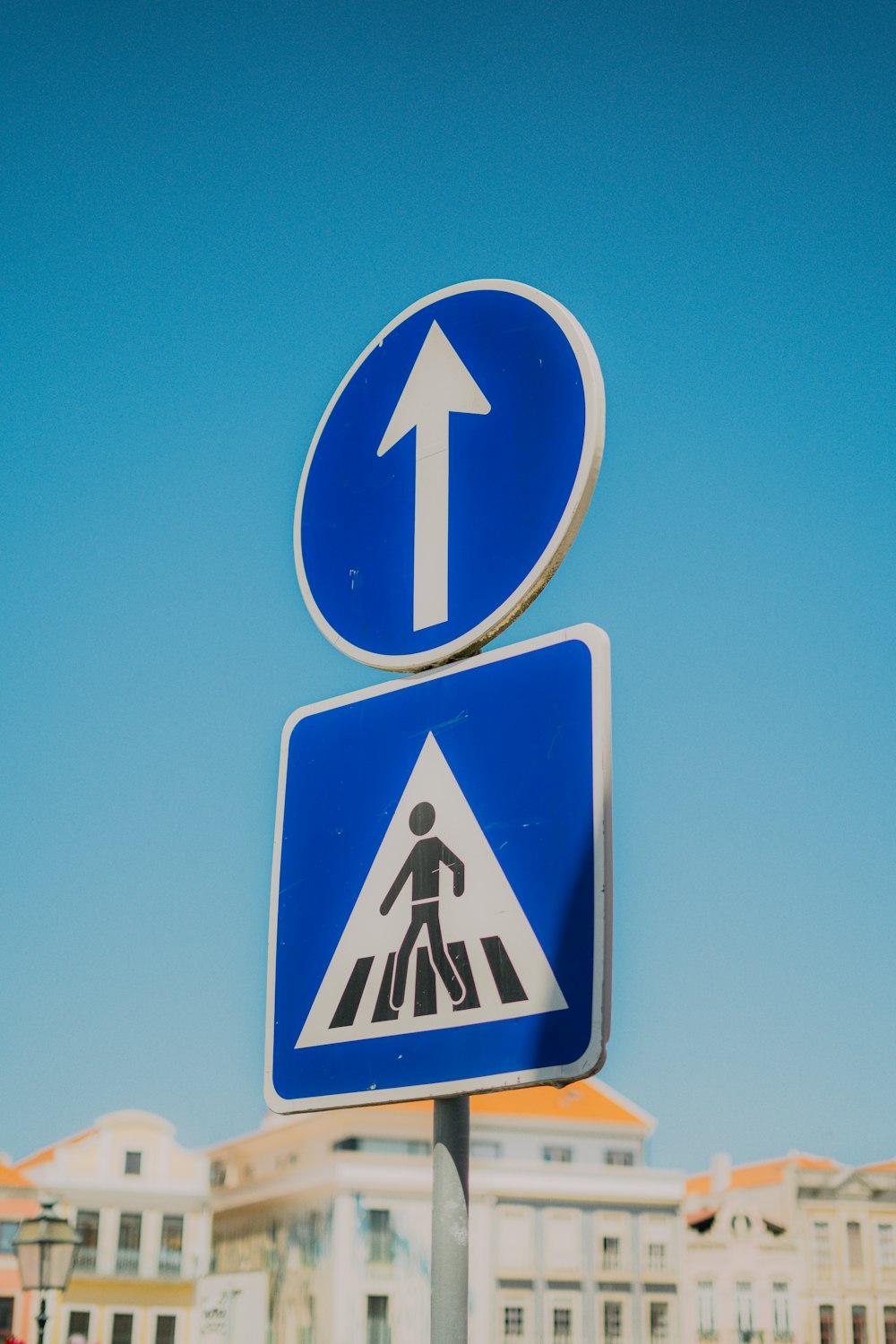 a blue and white street sign with an arrow pointing to the left
