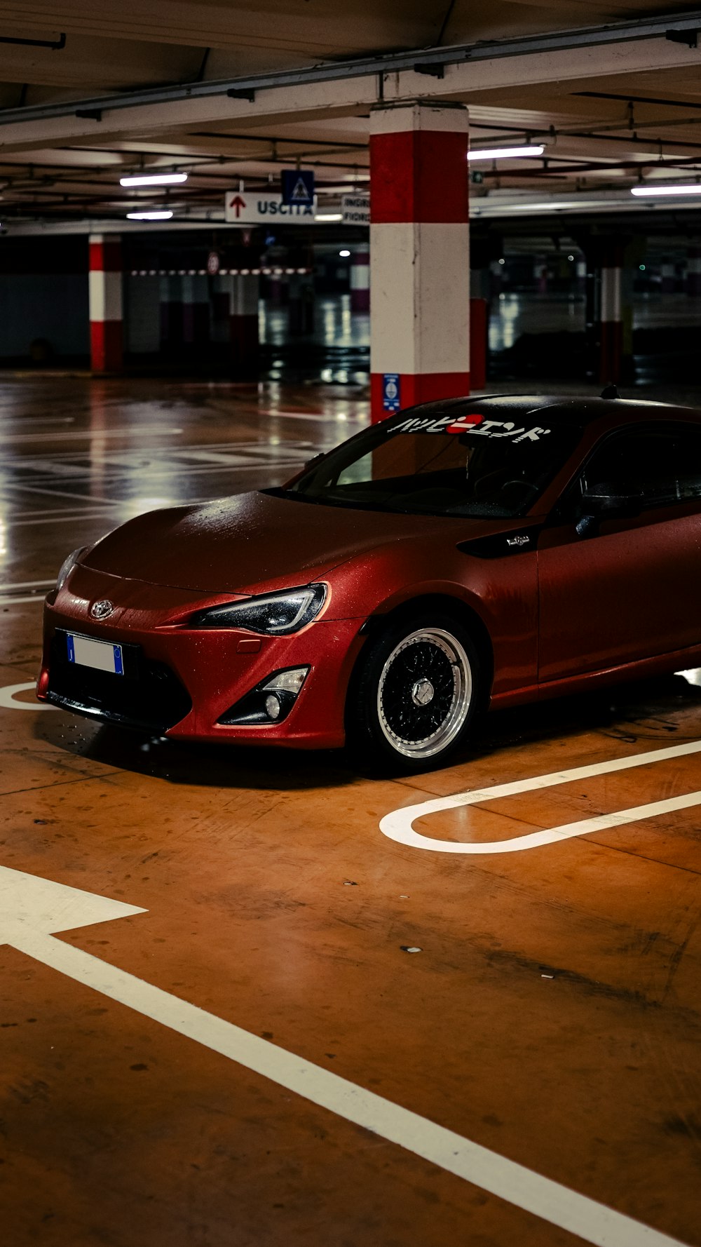 a red sports car parked in a parking garage