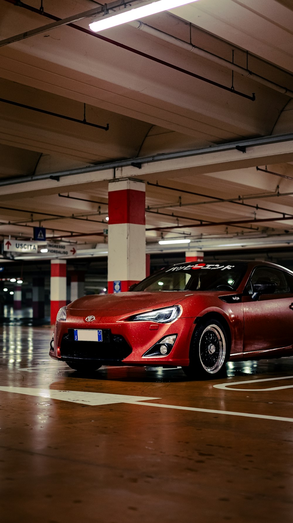 a red sports car parked in a parking garage