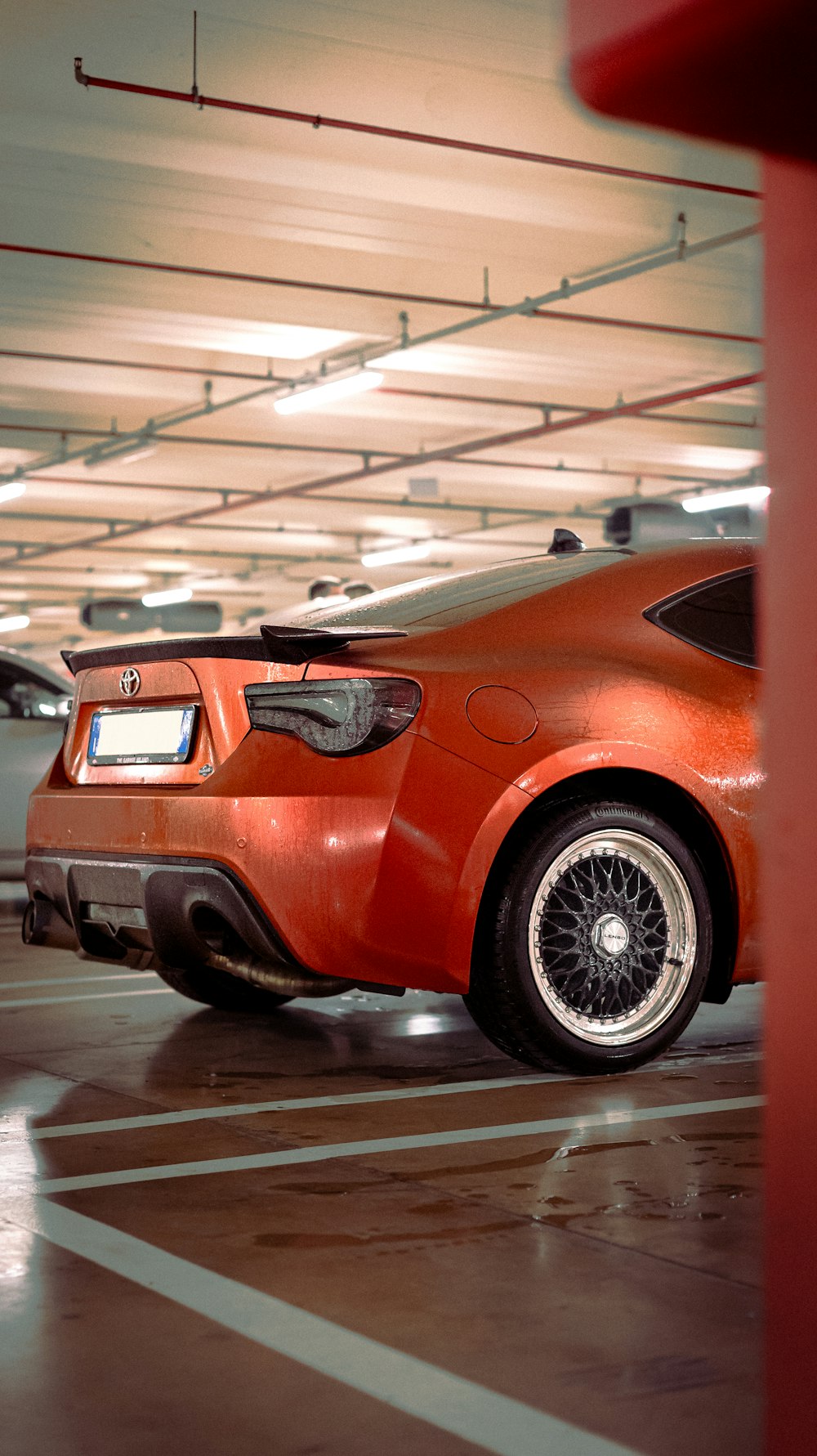 an orange sports car parked in a parking garage
