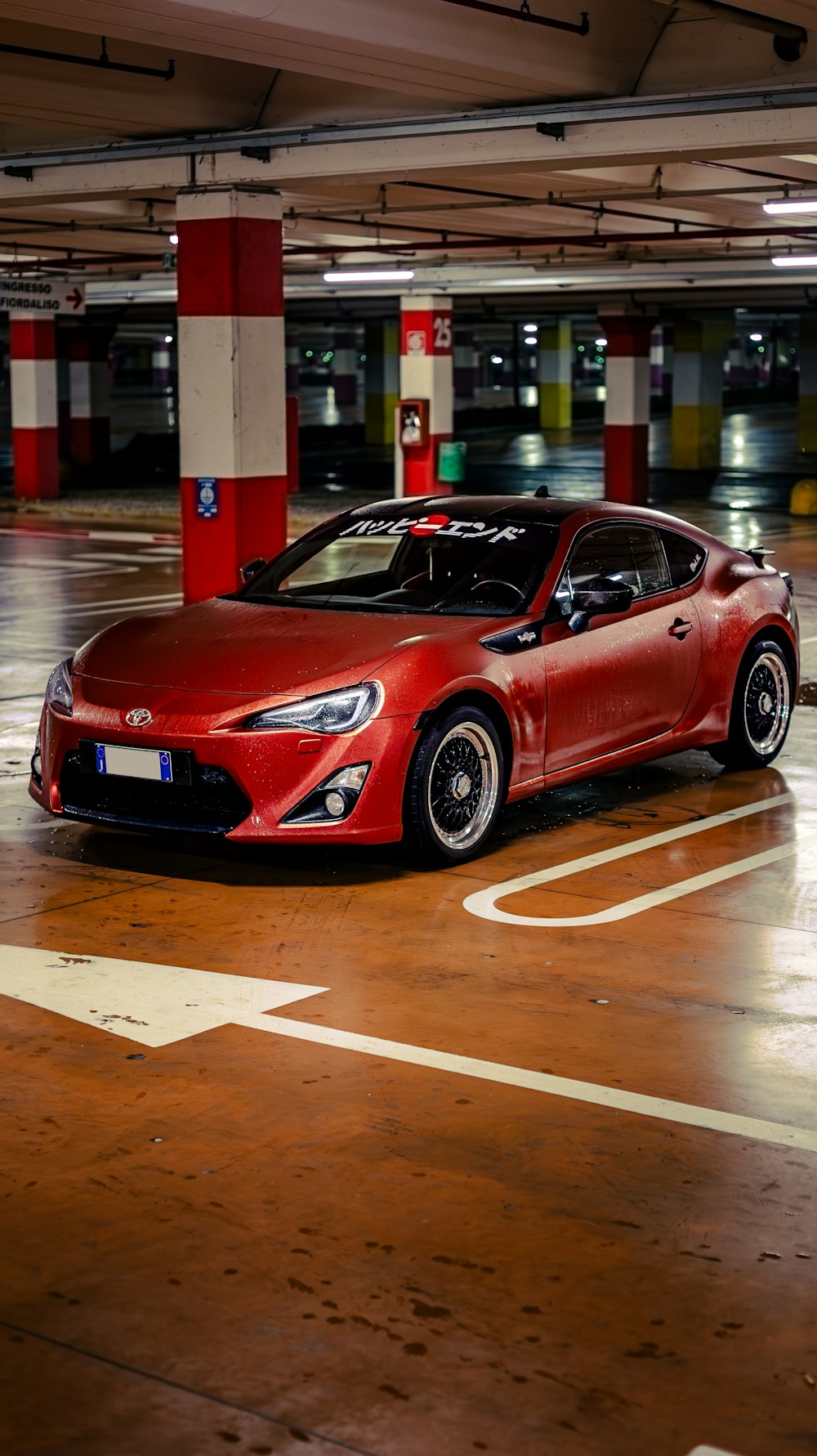 a red sports car parked in a parking garage