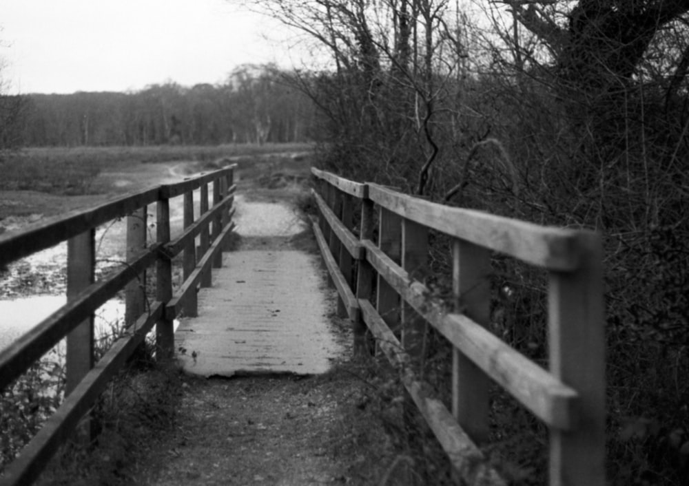 a black and white photo of a wooden bridge