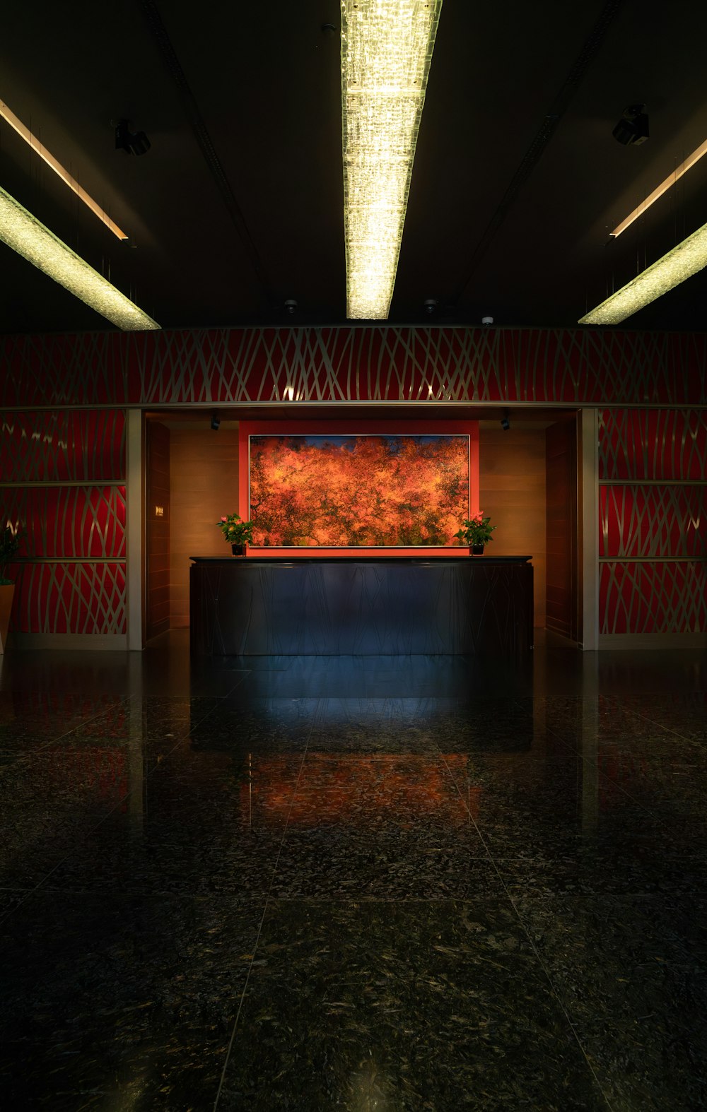 a dimly lit lobby with a large painting on the wall