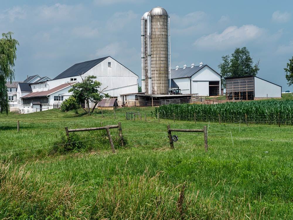 a farm with a barn and silos in the background