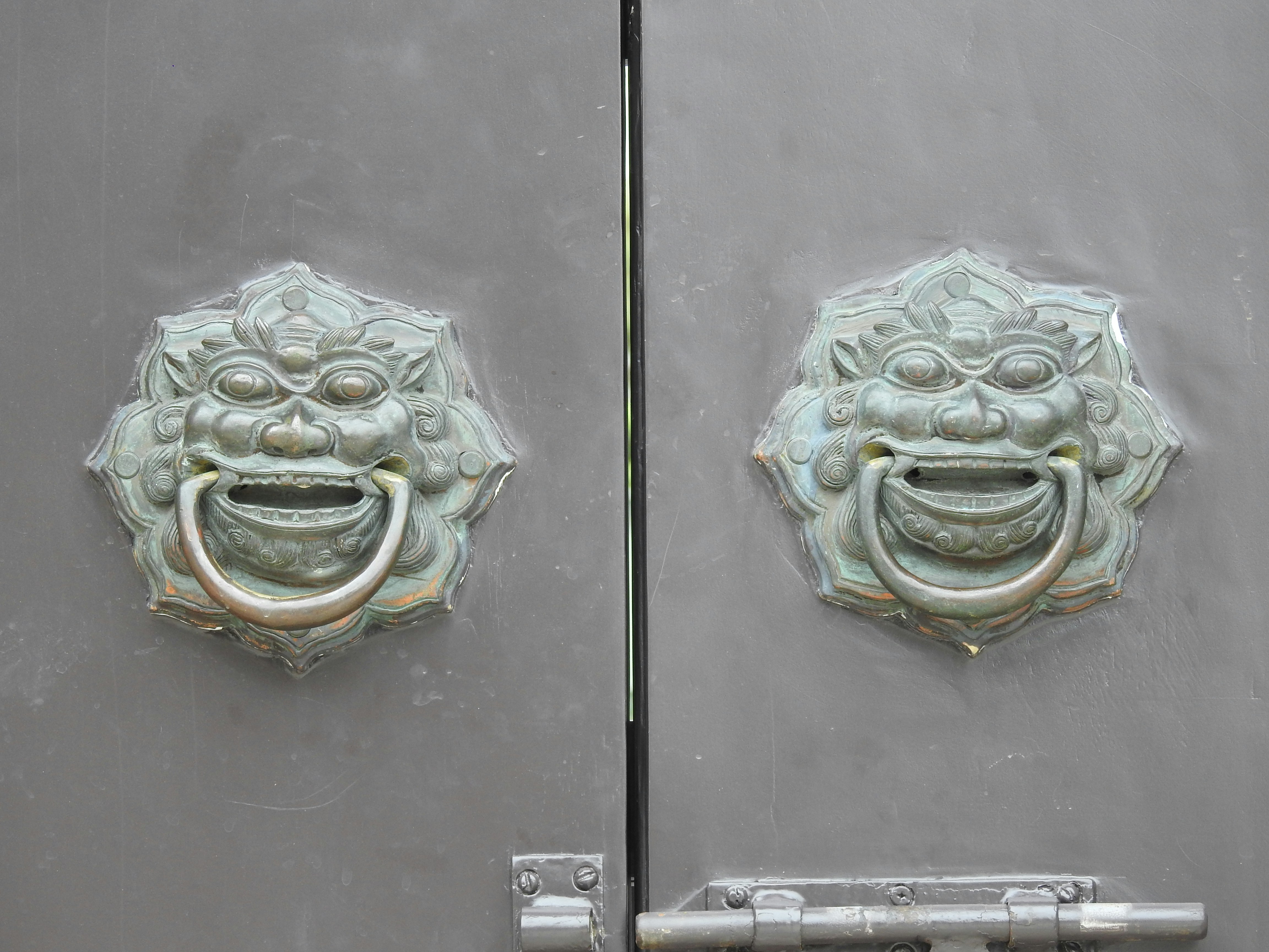 顔が描かれた金属製のドアのクローズアップ