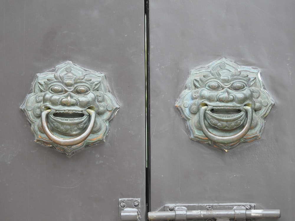 a close up of a metal door with a face on it