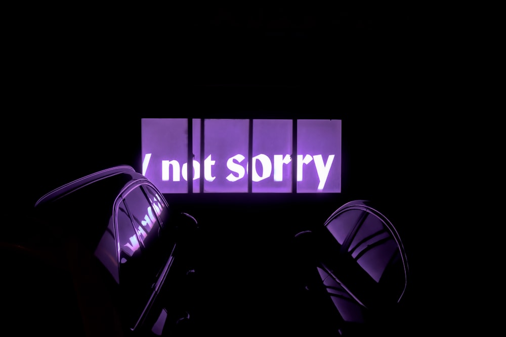 a purple neon sign that reads,'nit sorry '