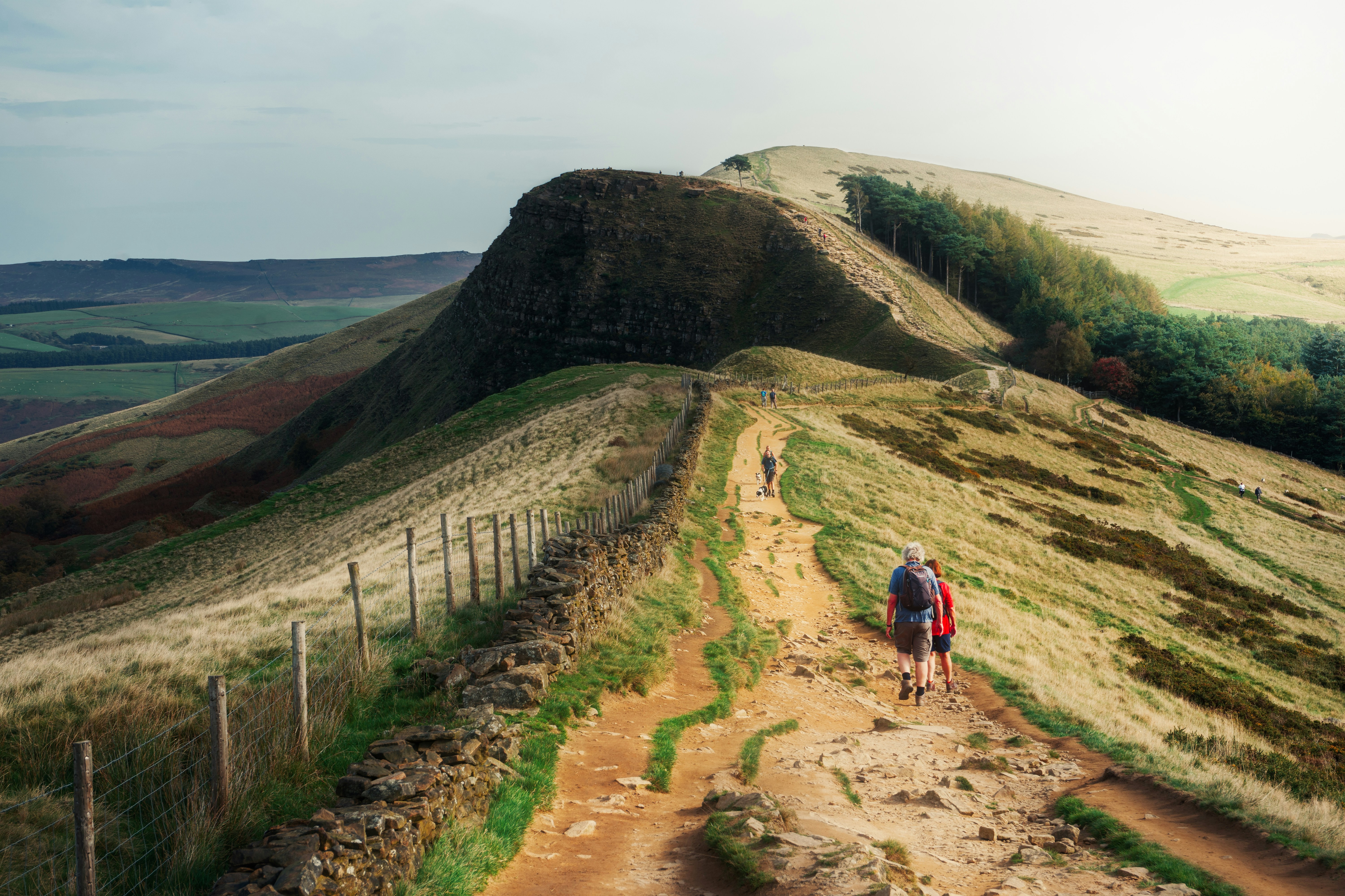 a couple of people walking down a dirt road