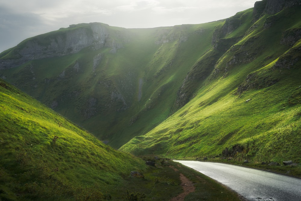 a winding road in the middle of a lush green valley