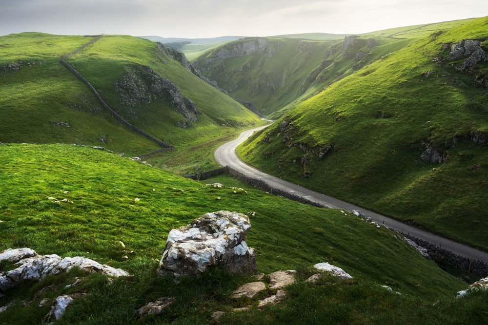 a road winding through a lush green valley