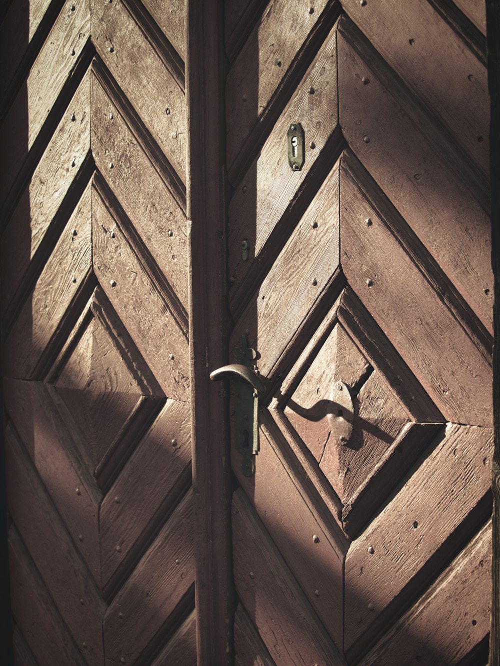 a close up of a door handle on a wooden door