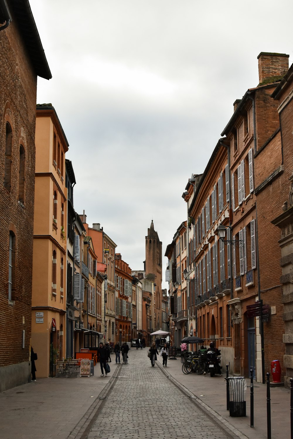 a cobblestone street lined with tall brick buildings