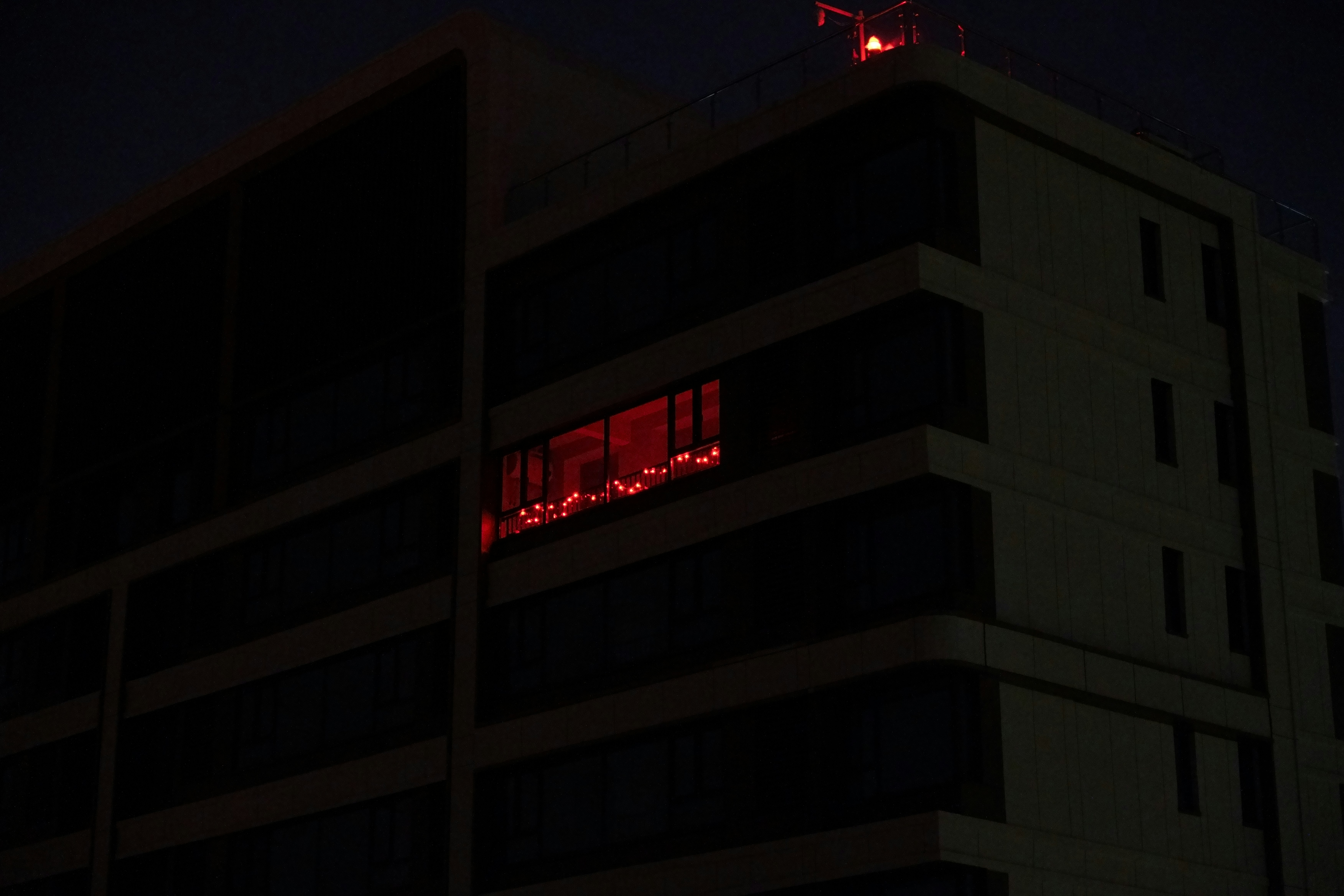a tall building with a red light on top of it