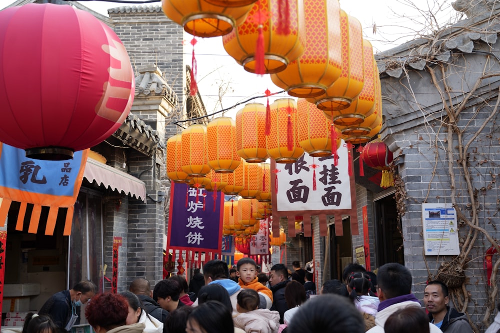 a group of people walking down a street under lanterns