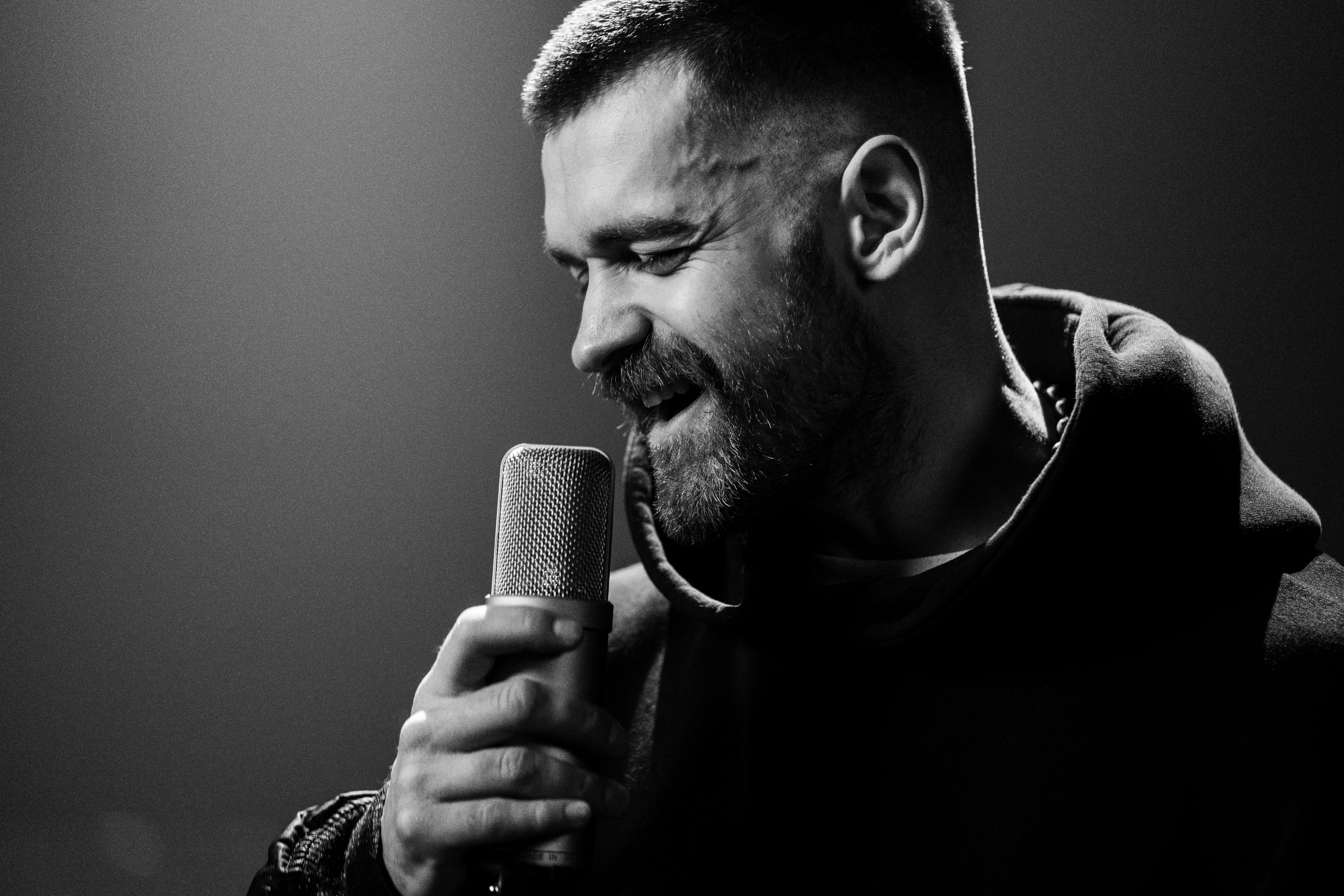 a man holding a microphone in his right hand