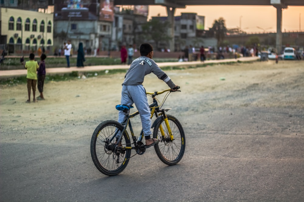 a man riding a bike down a dirt road