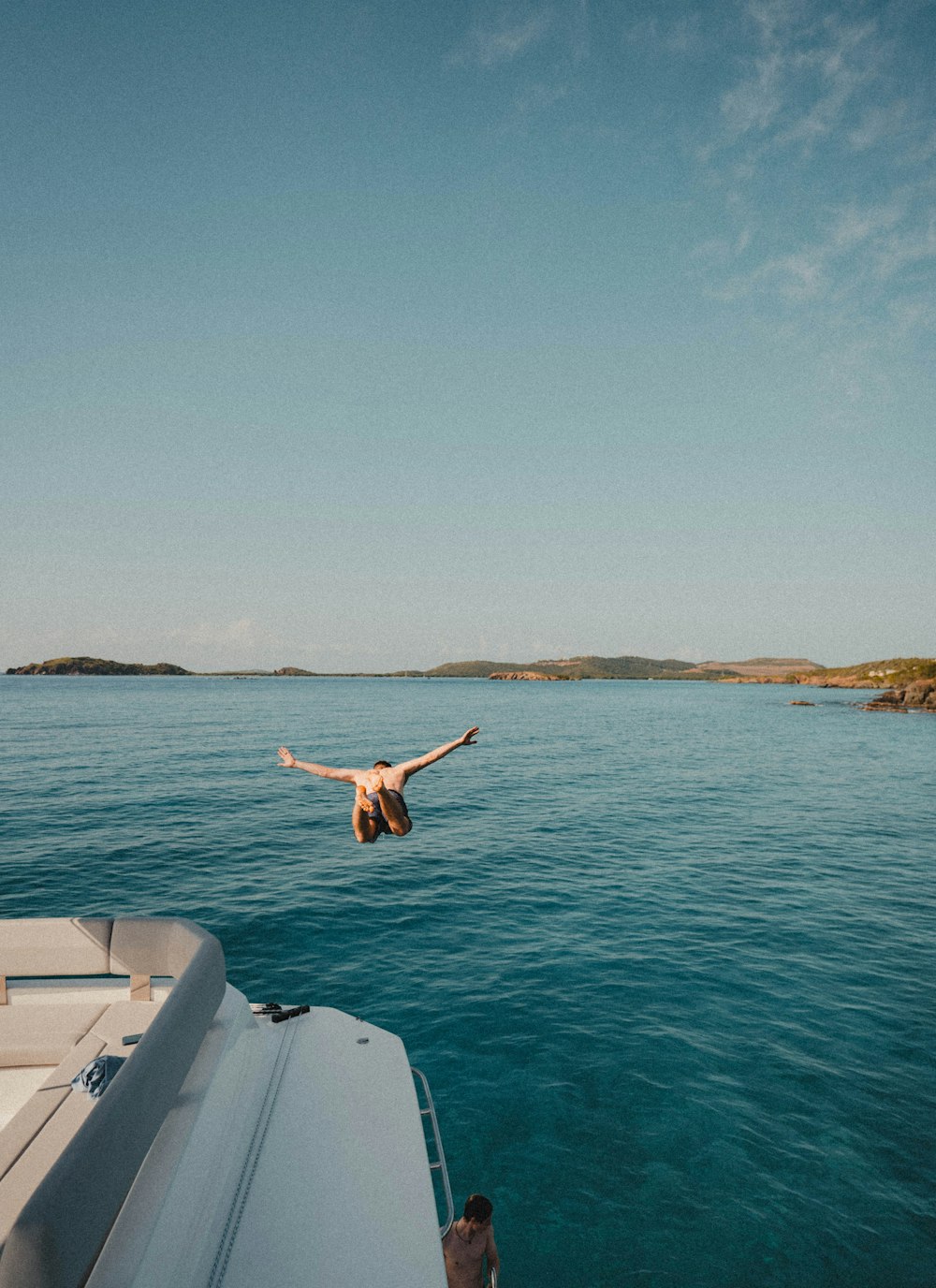 a person diving into the water from a boat