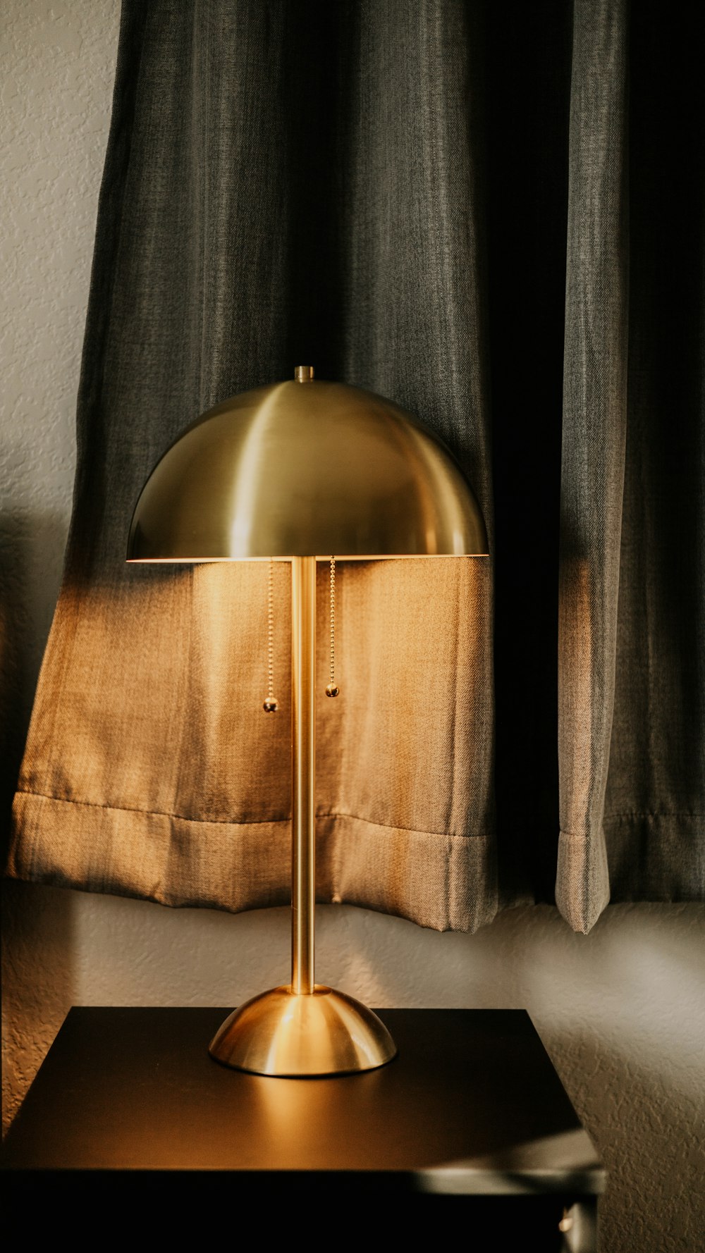 a lamp sitting on top of a table next to a window