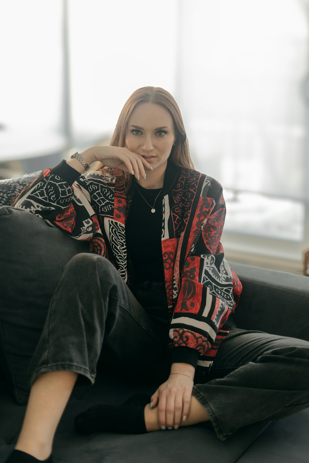 a woman sitting on top of a couch next to a window