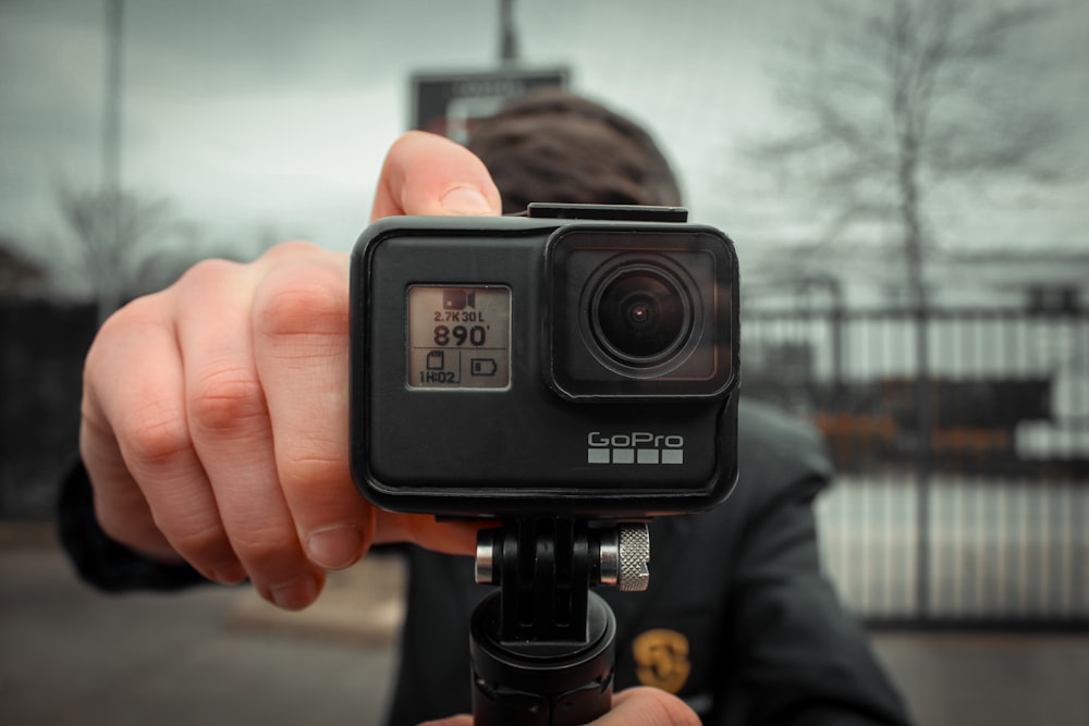 a person holding a camera with a camera attached to it