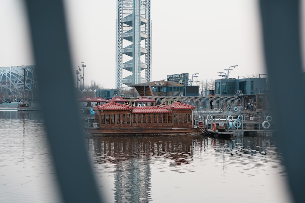 a boat floating on top of a lake next to a tall building