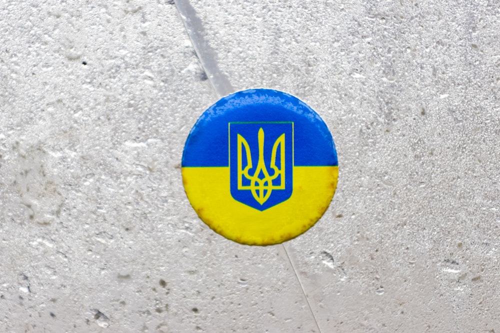 a blue and yellow frisbee with a coat of arms on it