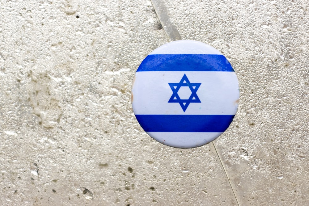 a blue and white button with a star of david on it