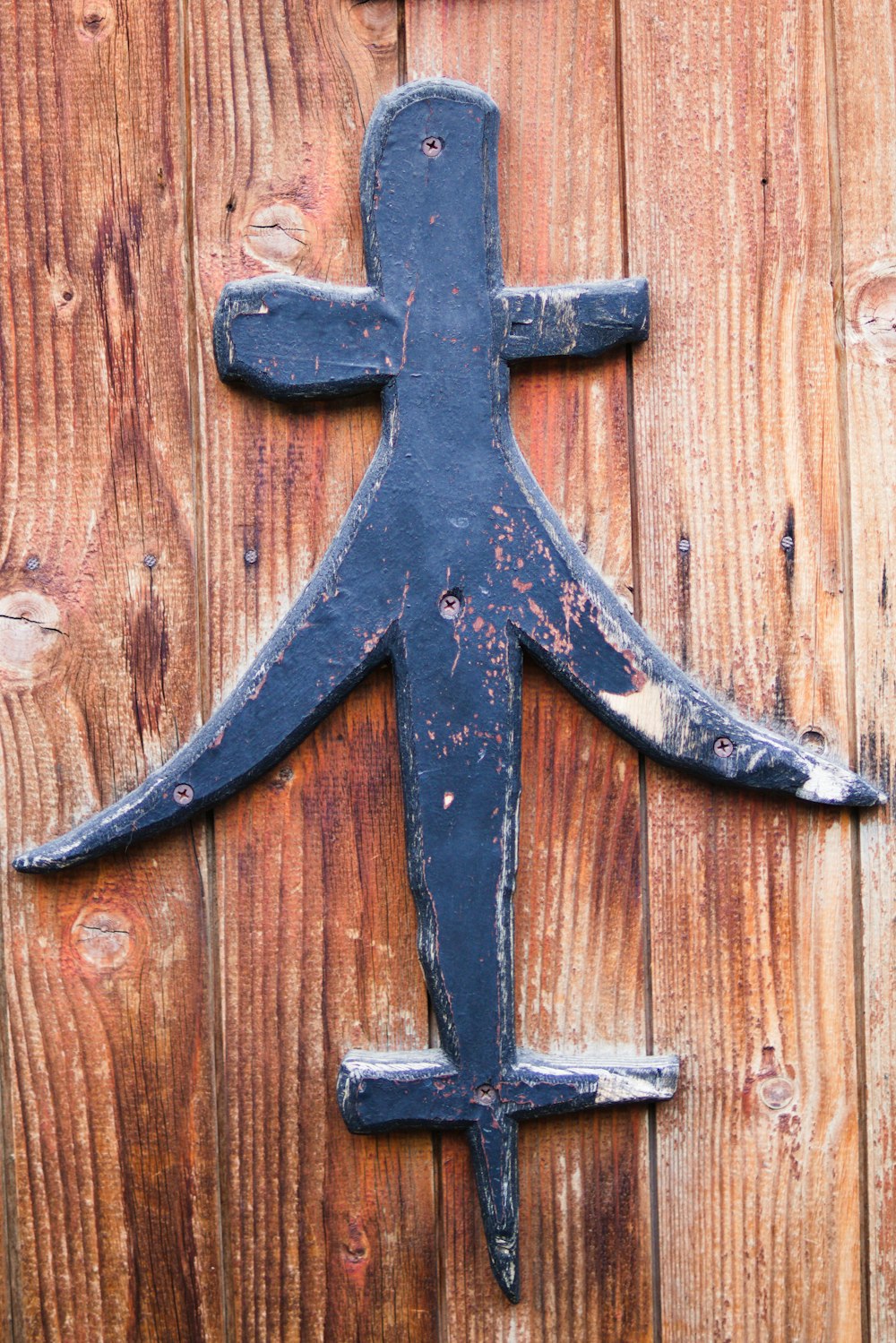 a wooden door with a metal figure on it