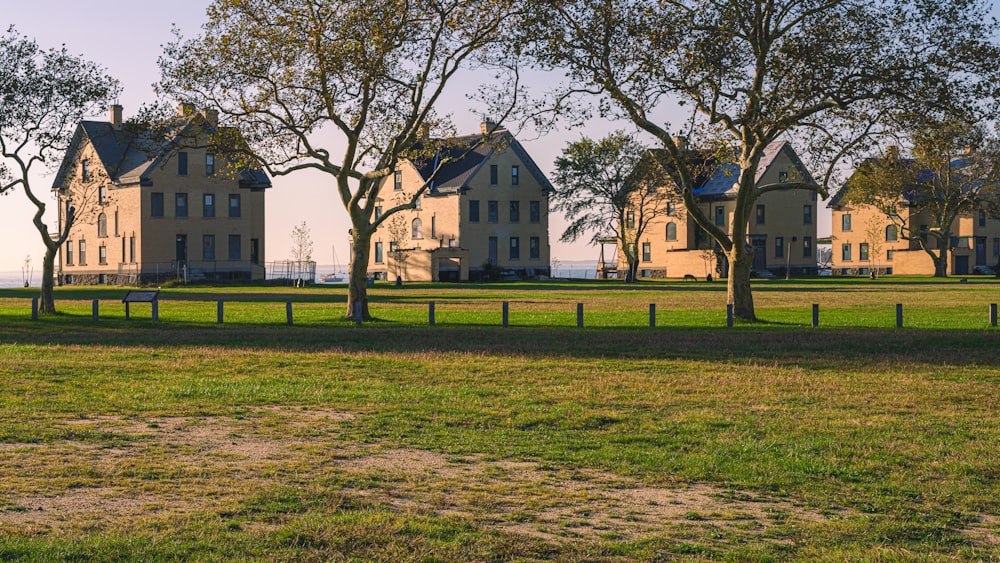 a row of houses sitting on top of a lush green field