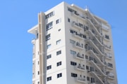 a tall white building with a bunch of balconies on it