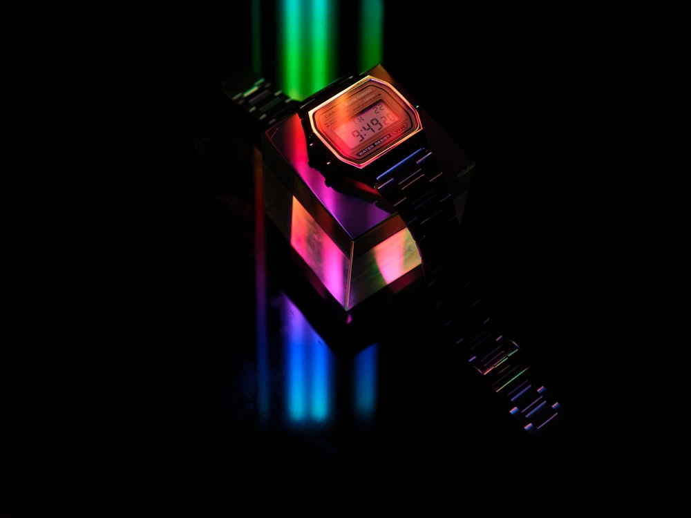 a watch with multicolored lights on a black background