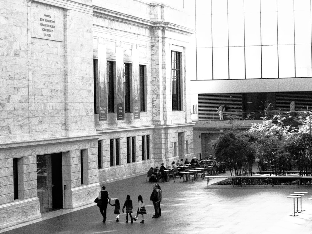 a black and white photo of people walking in a courtyard