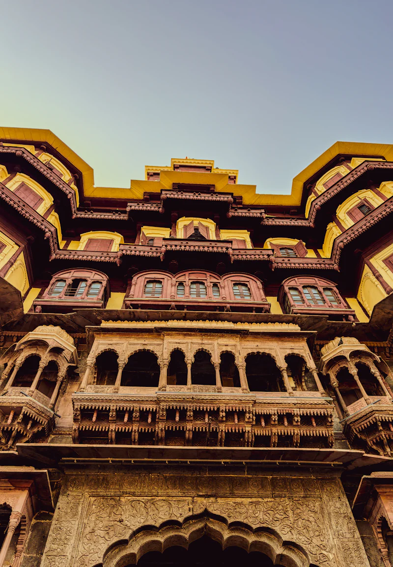 ornate palace facade with arched balconies, looking up