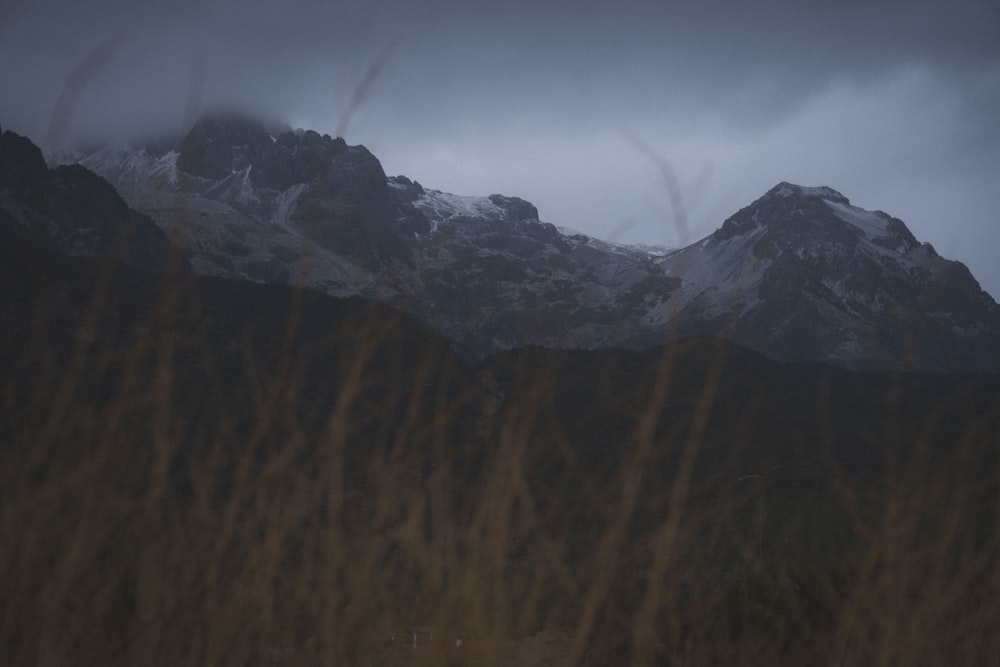 a view of a snowy mountain range from a field