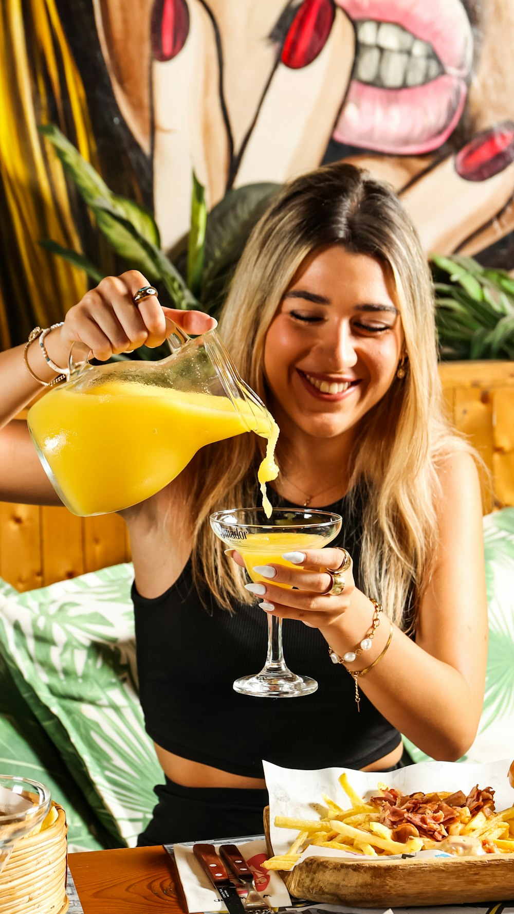 a woman pouring a drink into a glass