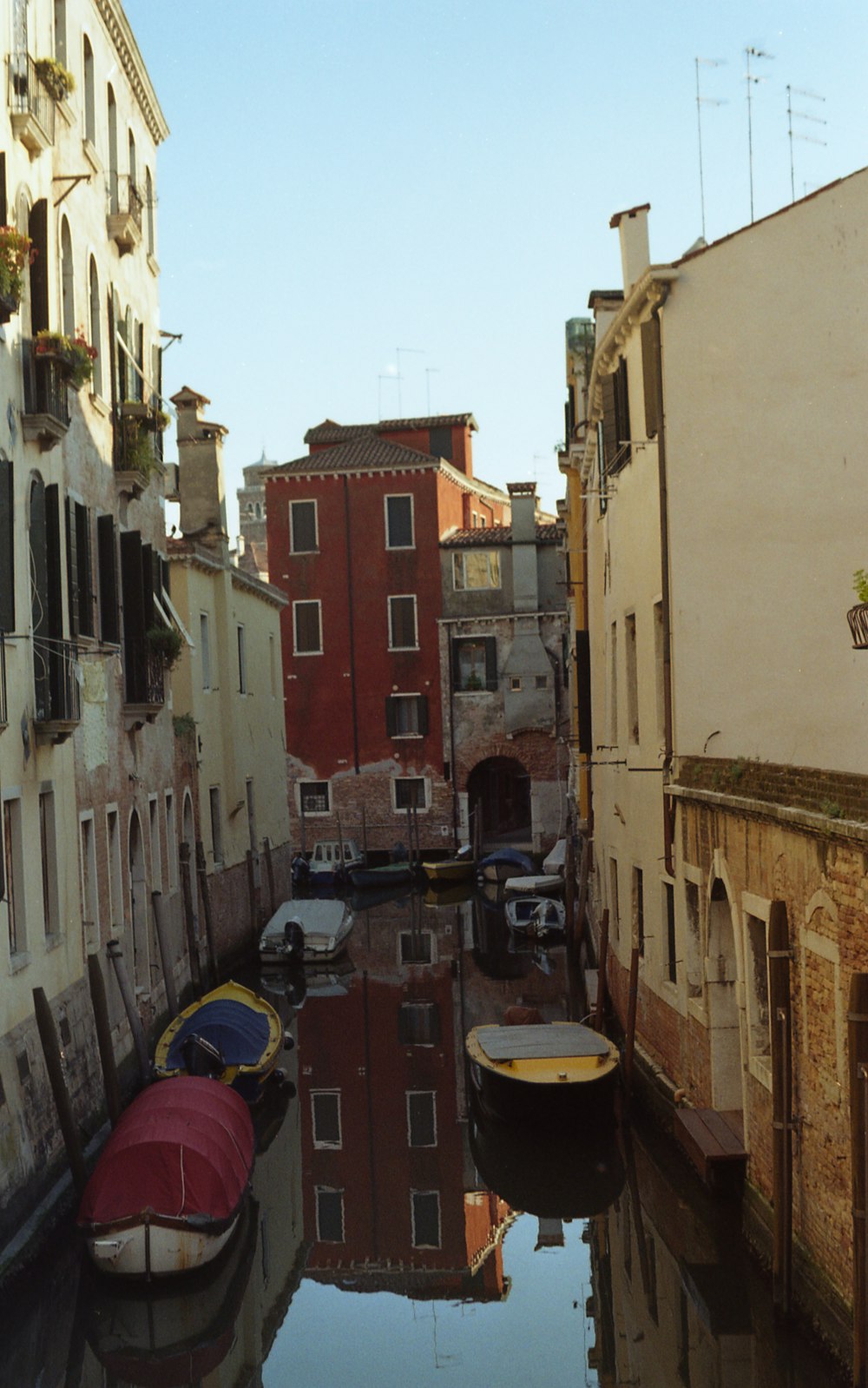 a narrow canal with several boats in it