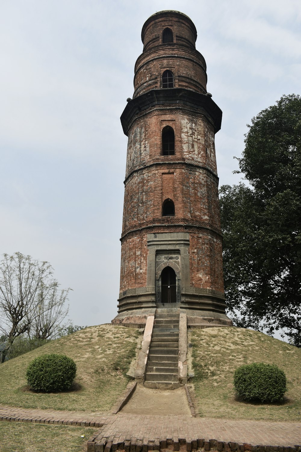 a tall tower sitting on top of a lush green hillside