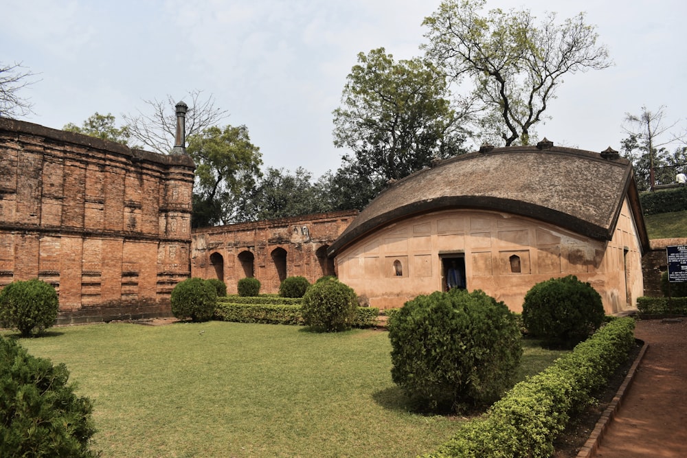 a building with a round roof surrounded by hedges