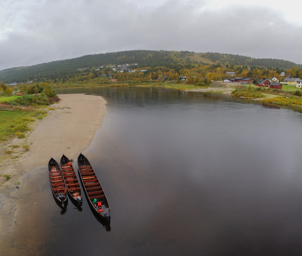 two canoes sitting on the shore of a lake