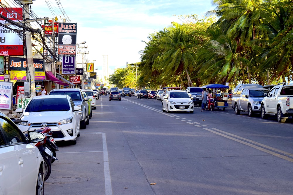 a street filled with lots of traffic next to tall palm trees